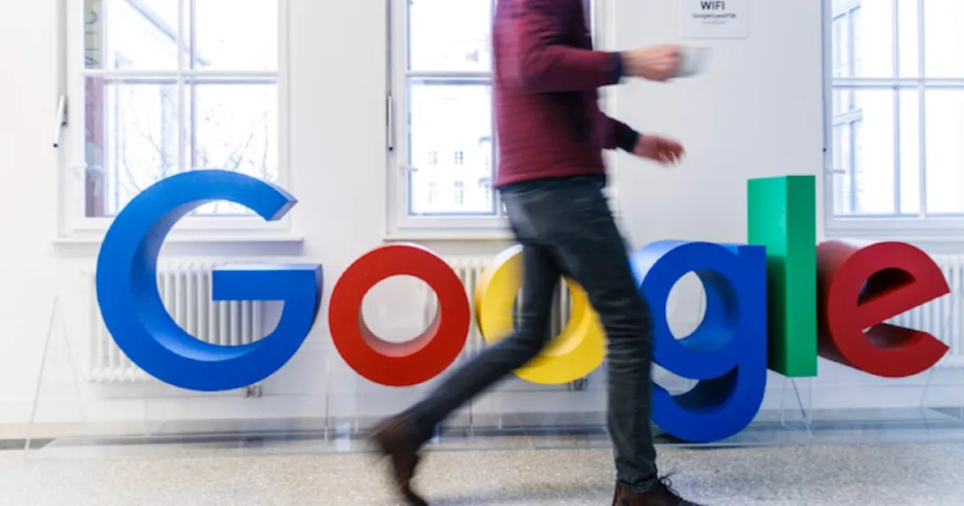 A person walking by the Google logo