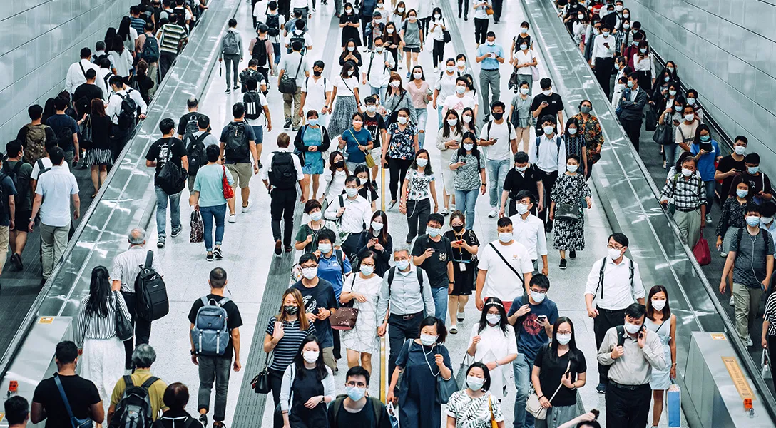 Crowd of commuters wearing masks