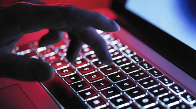 Cybersecurity - hacker's hand at keyboard