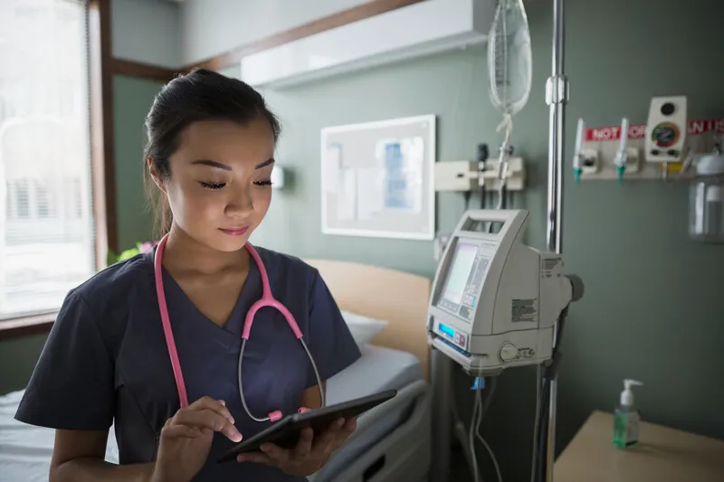A doctor looking at a tablet.