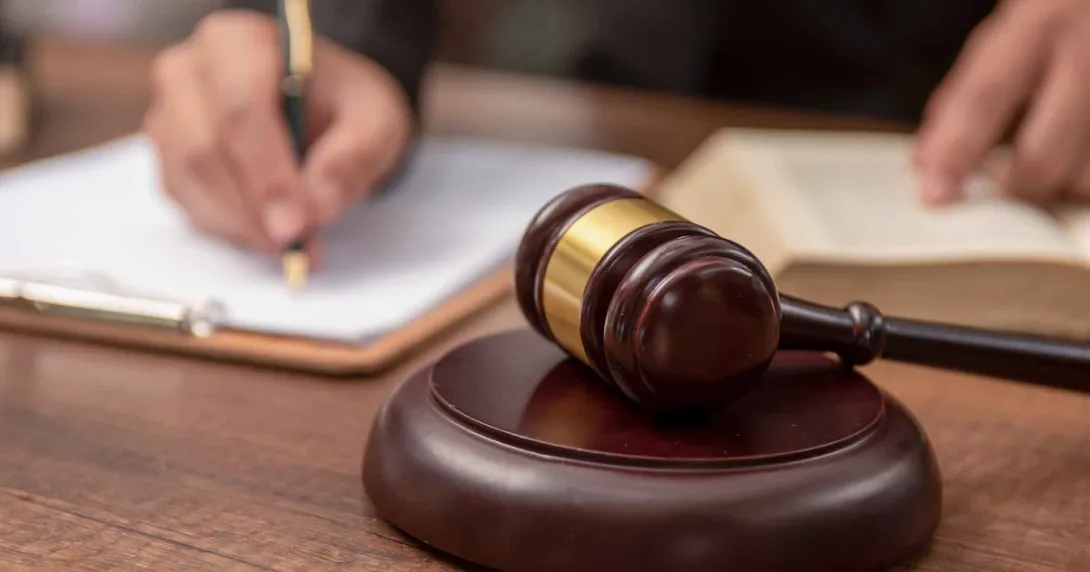 gavel with hand writing in the background