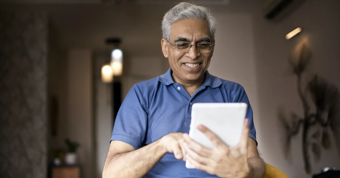 Person smiles as they use an app on a tablet. Person smiles as they use an app on a tablet.