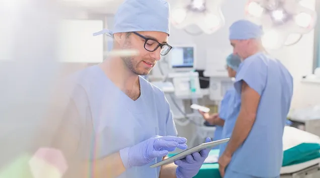 Medical worker in scrubs using a tablet