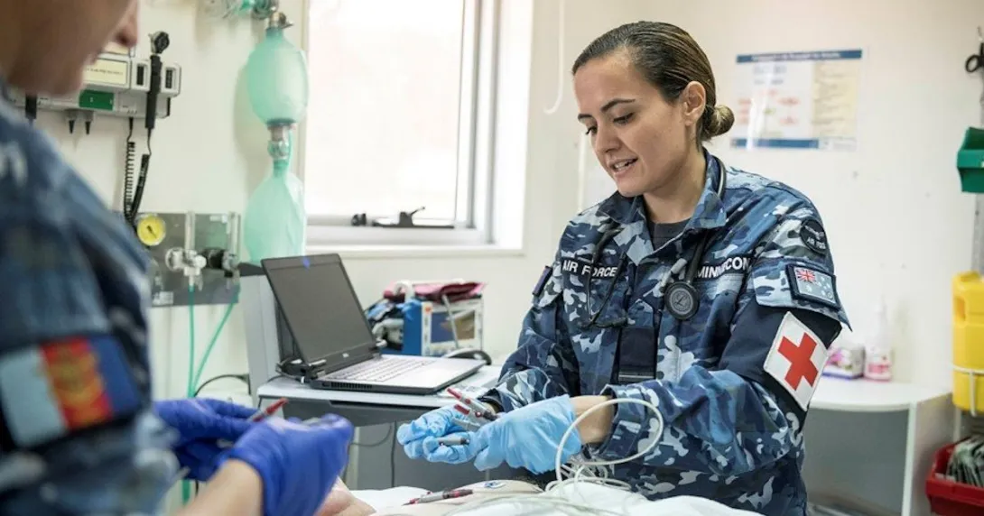 A military medical staff inserting tubes into a patient