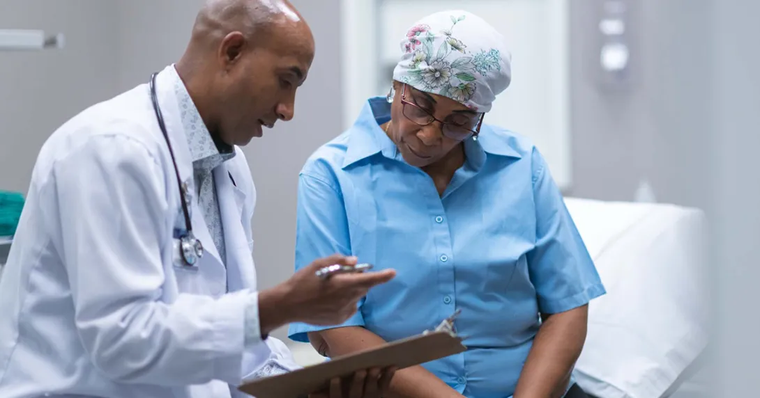 Doctor showing clipboard to cancer patient
