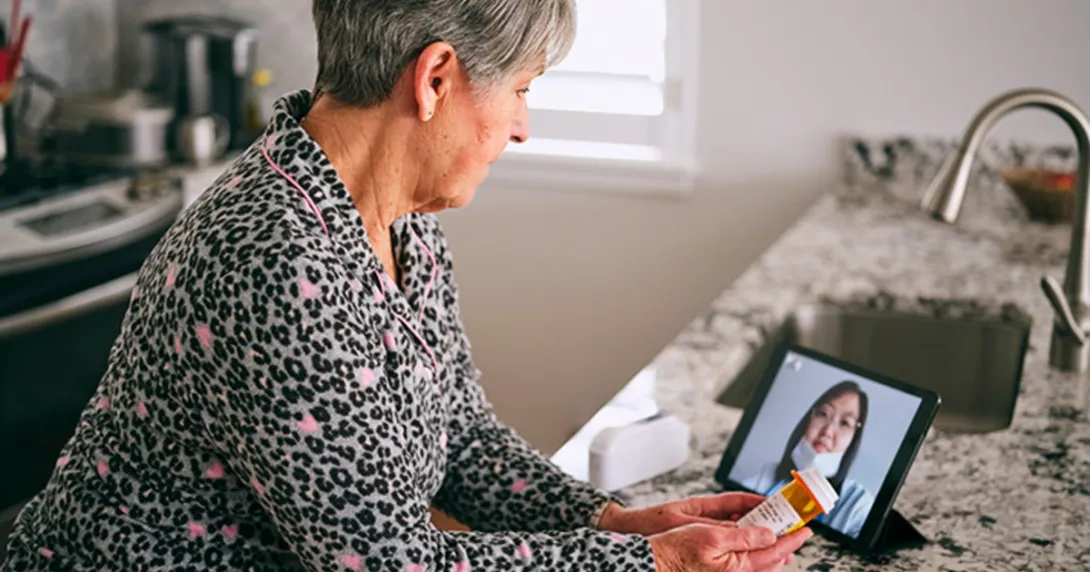 A patient looks at a doctor's face on a tablet screen
