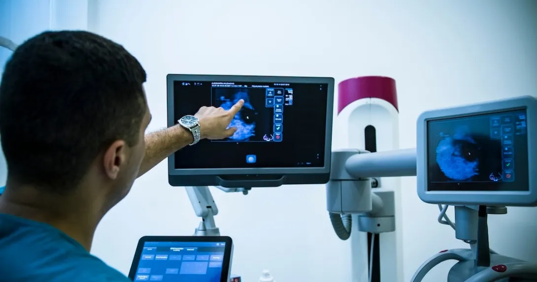 Healthcare worker pointing at x-ray image on monitor