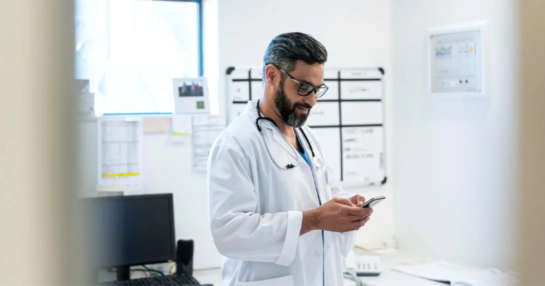 Doctor looking at smartphone Doctor looking at smartphone