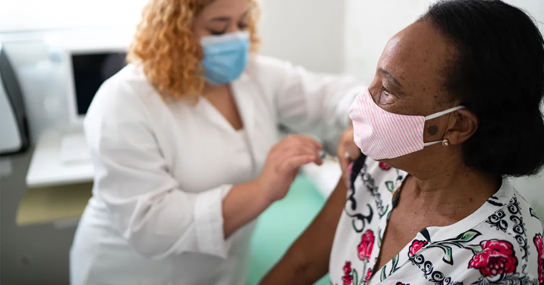 Nurse administers COVID-19 vaccine.