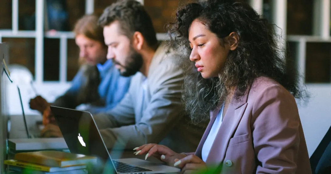 Three people working at laptops Three people working at laptops