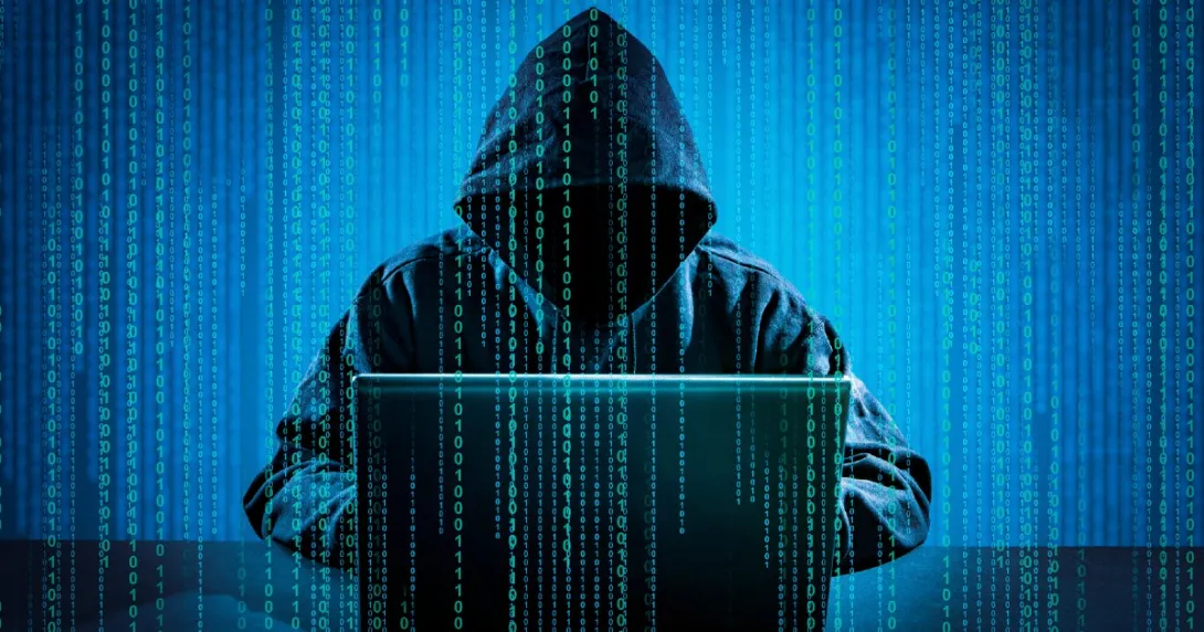 A person in a hooded sweatshirt on a computer