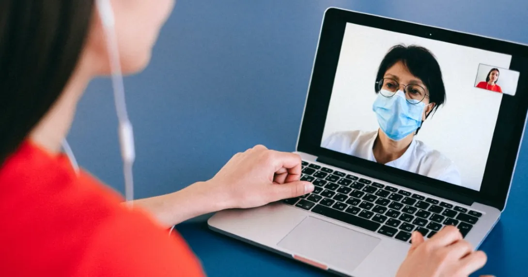 A patient speaks to a doctor on a computer