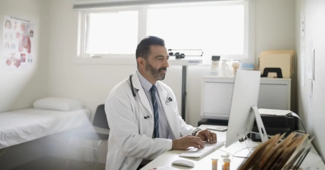 A person wearing a stethoscope on a computer