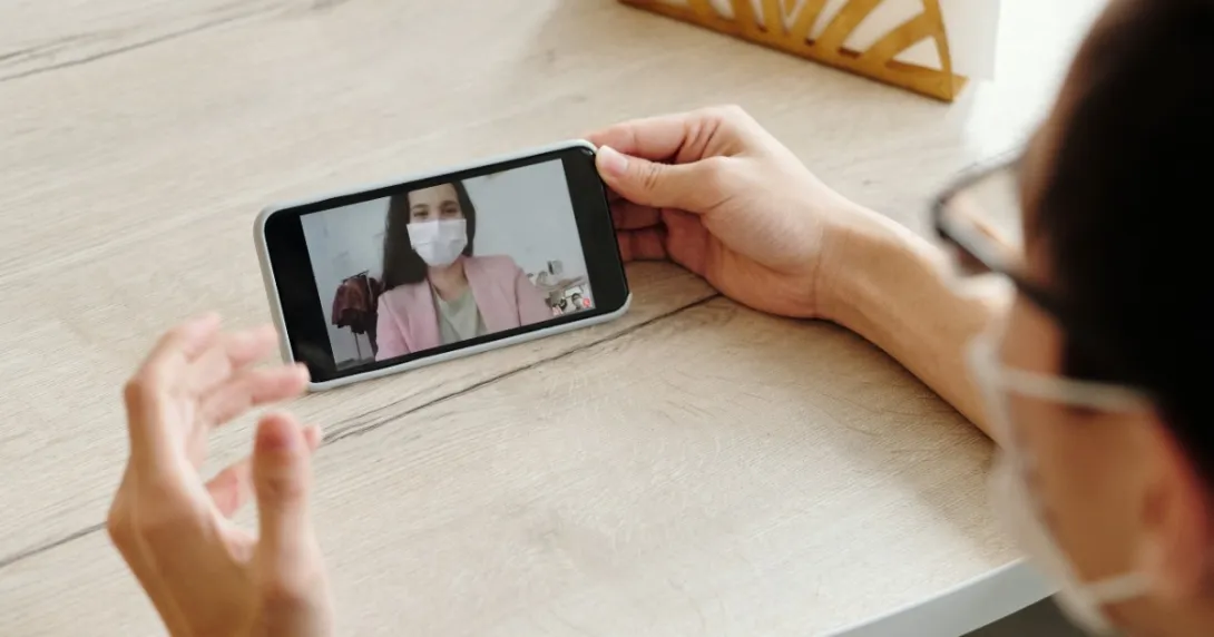 A doctor on a phone screen with a patient