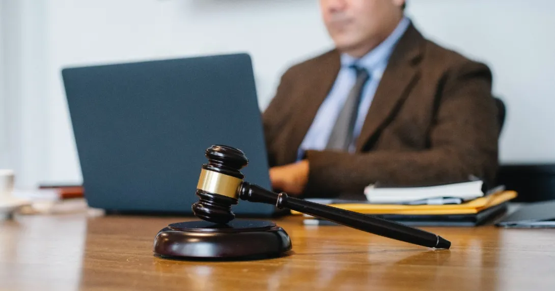 A gavel with a lawyer in the background