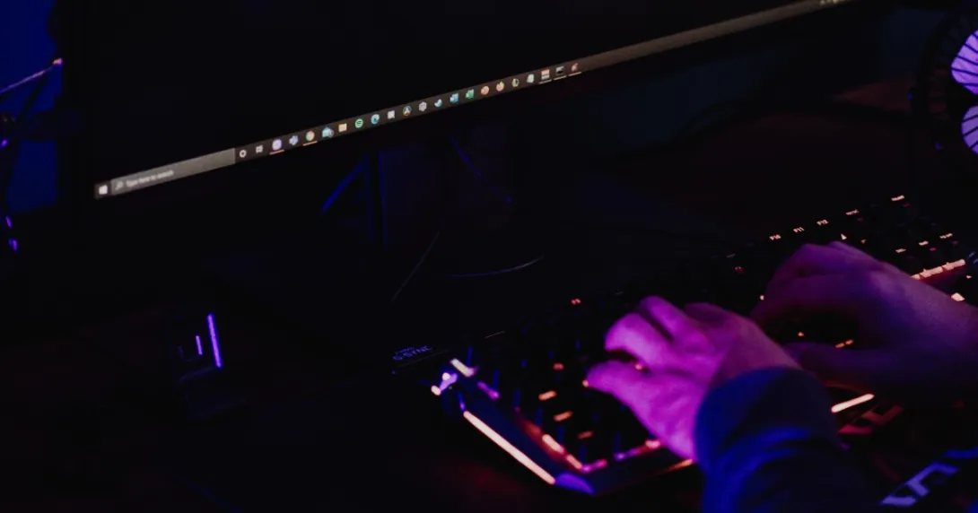 A pair of hands on a darkened keyboard