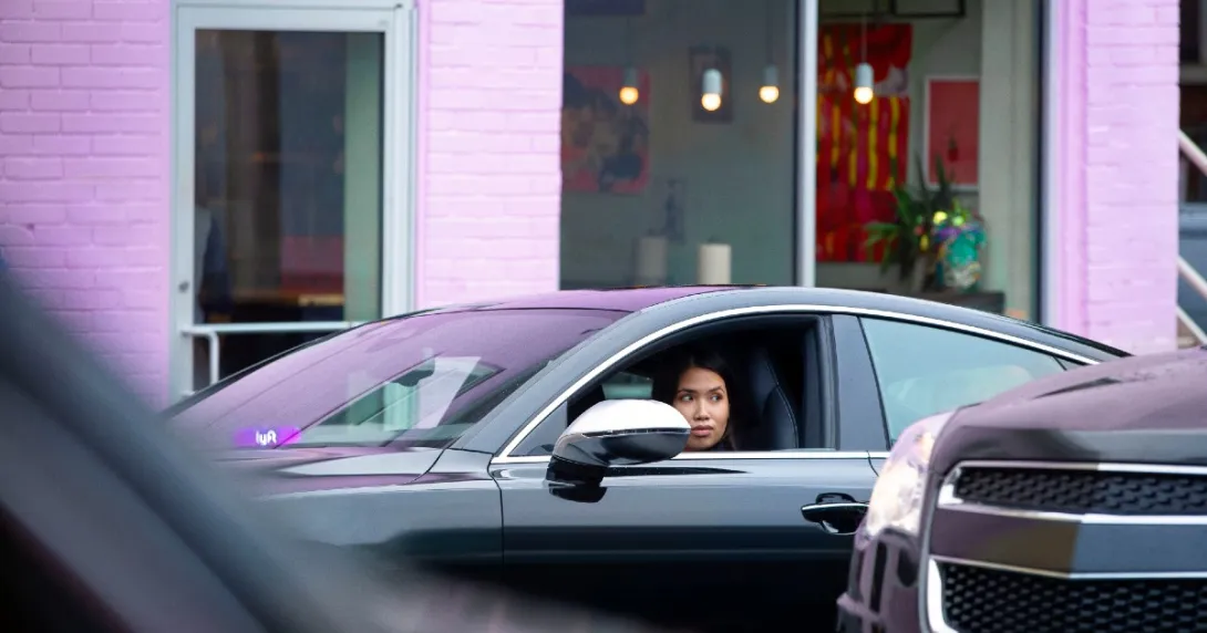 A driver sits in a Lyft