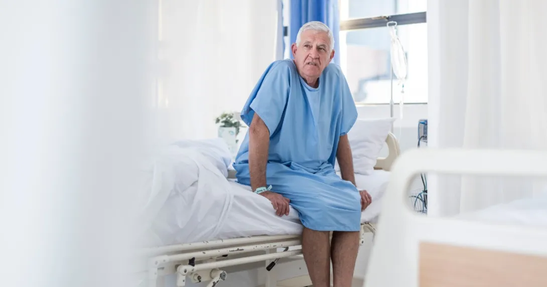 An older man seated on a hospital bed