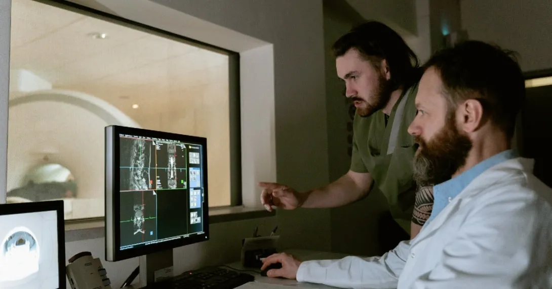 Two people look at diagnostic images on a screen Two people look at diagnostic images on a screen