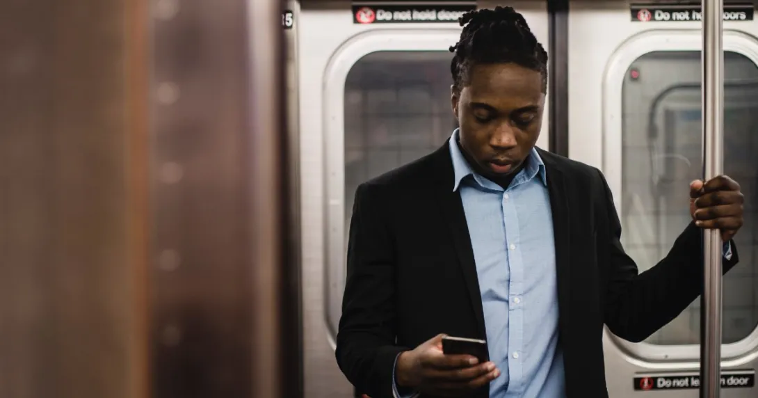 A person texting on a subway train