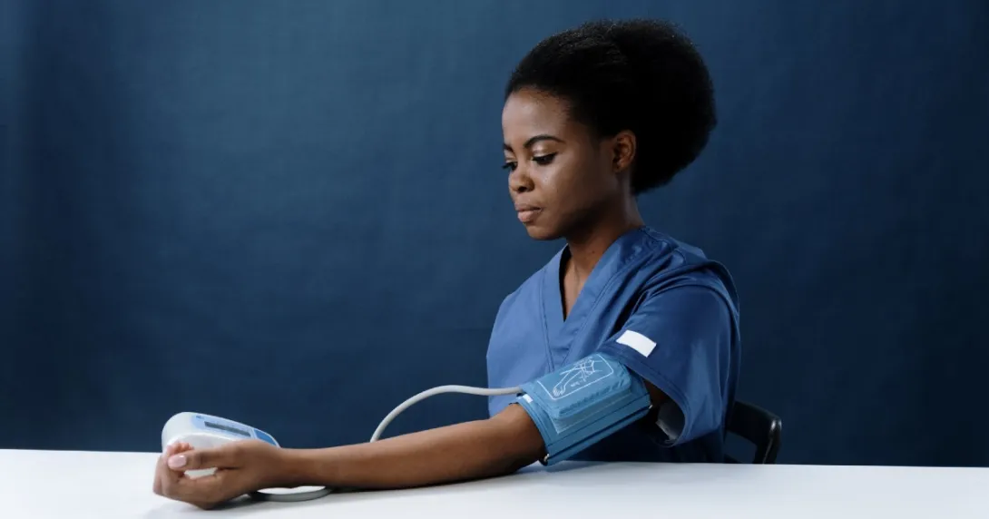 A clinician using a blood pressure monitor