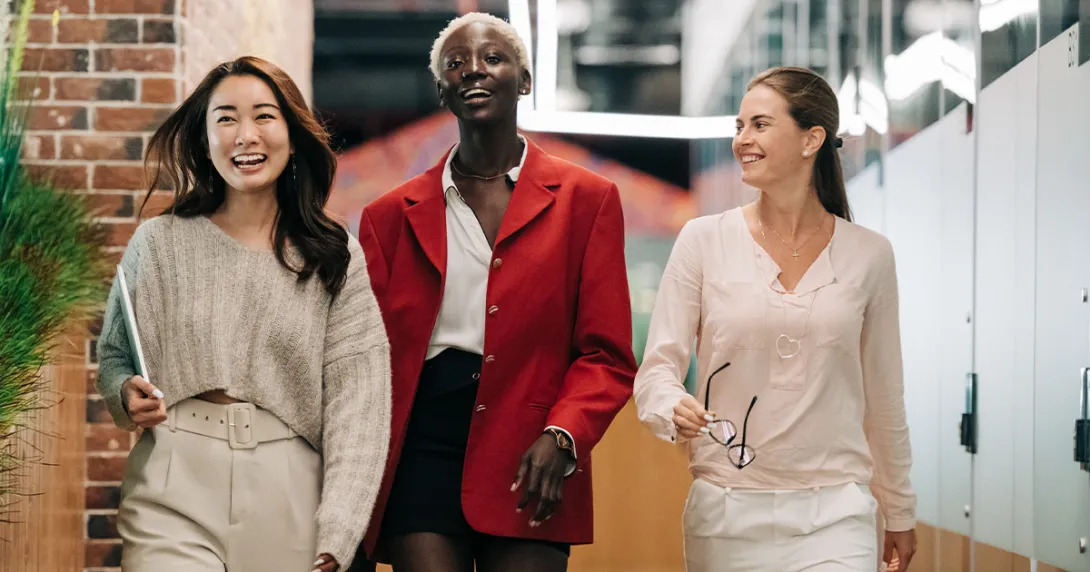 Three people walk toward the camera in an office setting. Three people walk toward the camera in an office setting.