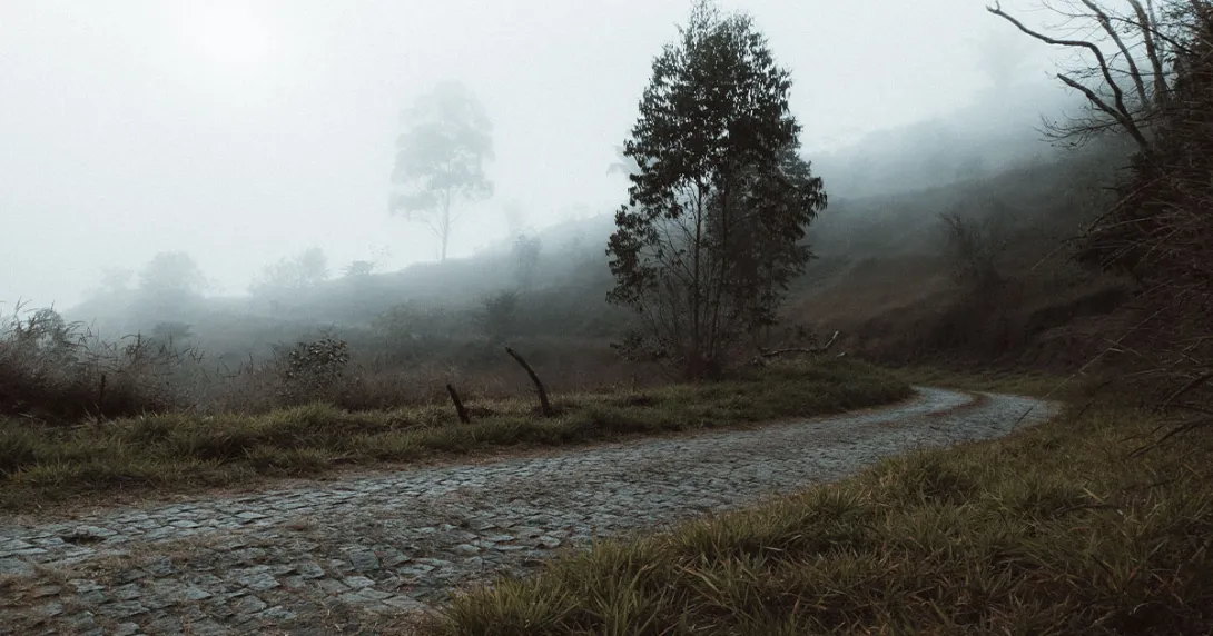 An old, uneven cobblestone road on a hillside in the mist An old, uneven cobblestone road on a hillside in the mist