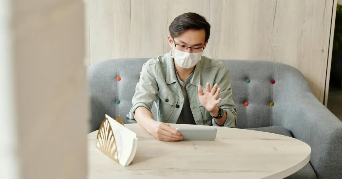 A patient wearing mask at home in an online consultation. A patient wearing mask at home in an online consultation.