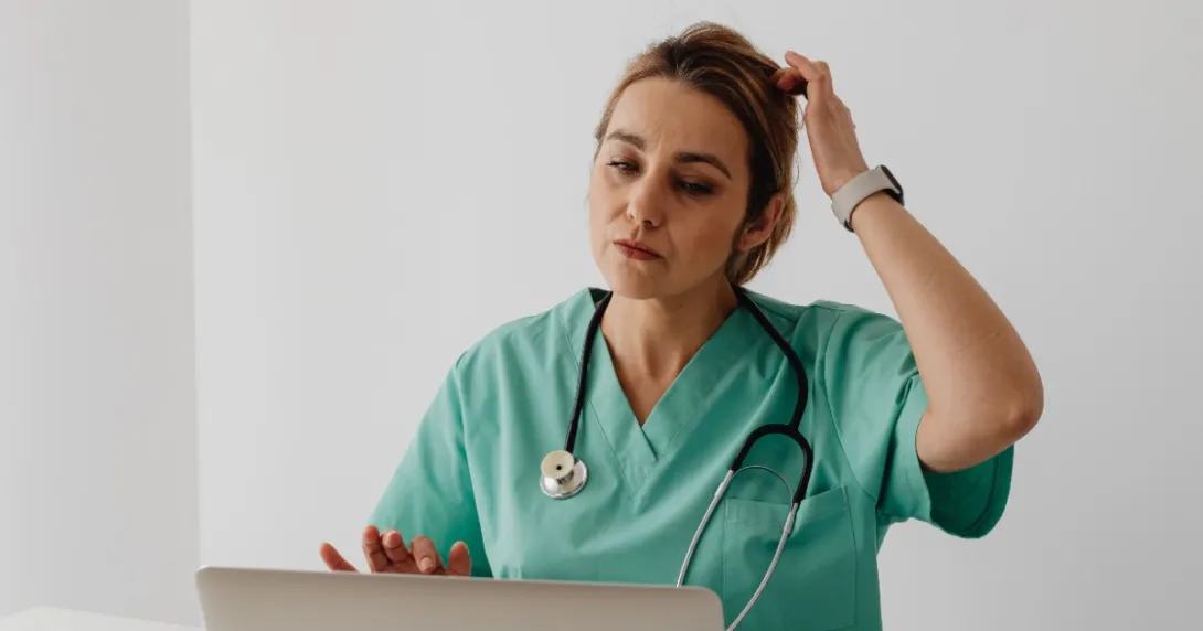 A person in scrubs on the computer