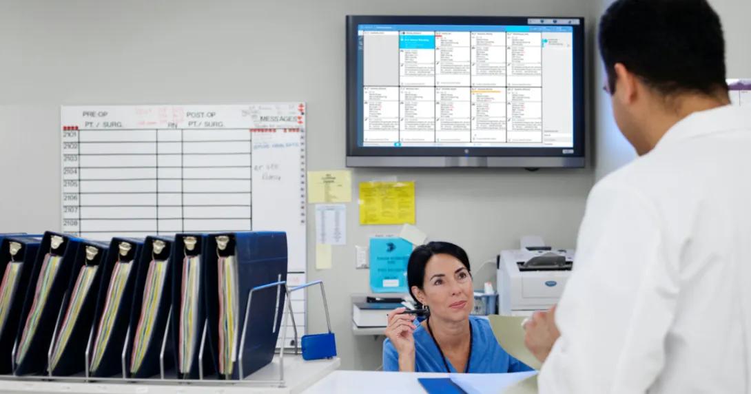 Staff conversing in the nurses' station with the Ascom Digistat Smart Central on the background Staff conversing in the nurses' station with the Ascom Digistat Smart Central on the background