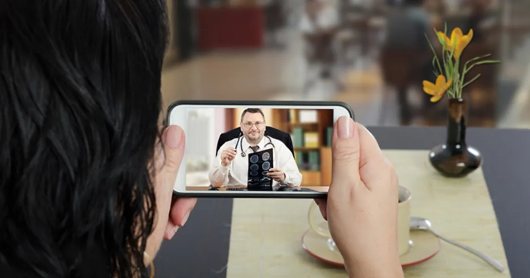 A patient looks at a doctor on a mobile phone screen