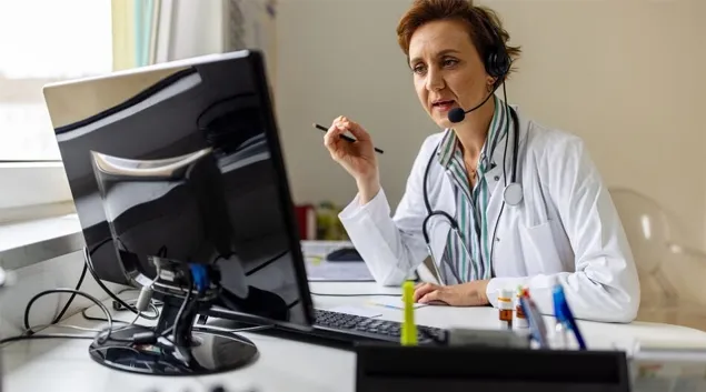 Doctor with headset talking to monitor