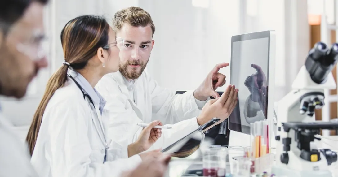 Lab workers looking at a monitor