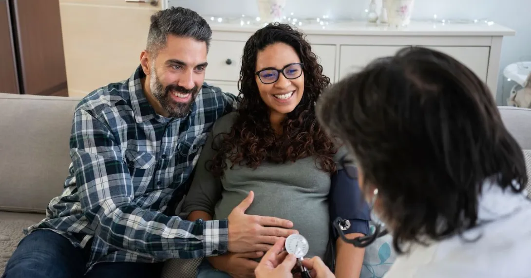 Pregnant couple talking to doctor