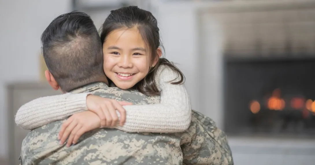 Servicemember hugs child Servicemember hugs child
