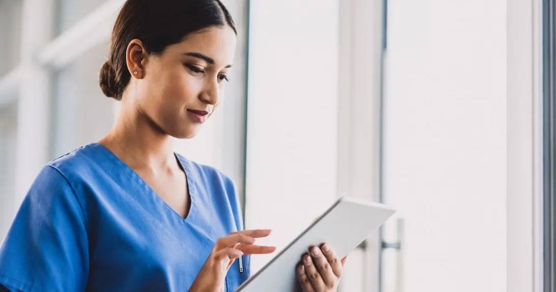 A clinician enters documentation on a tablet. A clinician enters documentation on a tablet.