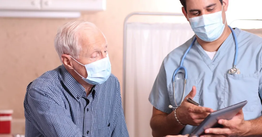 A doctor discussing a senior patient's results using a digital tablet