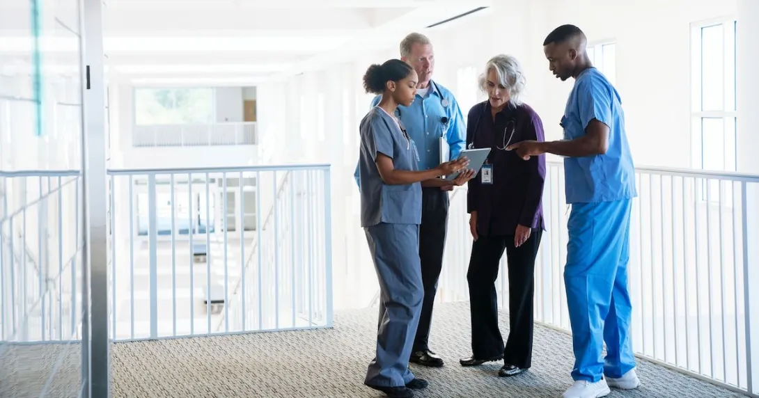 Nurses and doctors gather in a hallway for a discussion Nurses and doctors gather in a hallway for a discussion