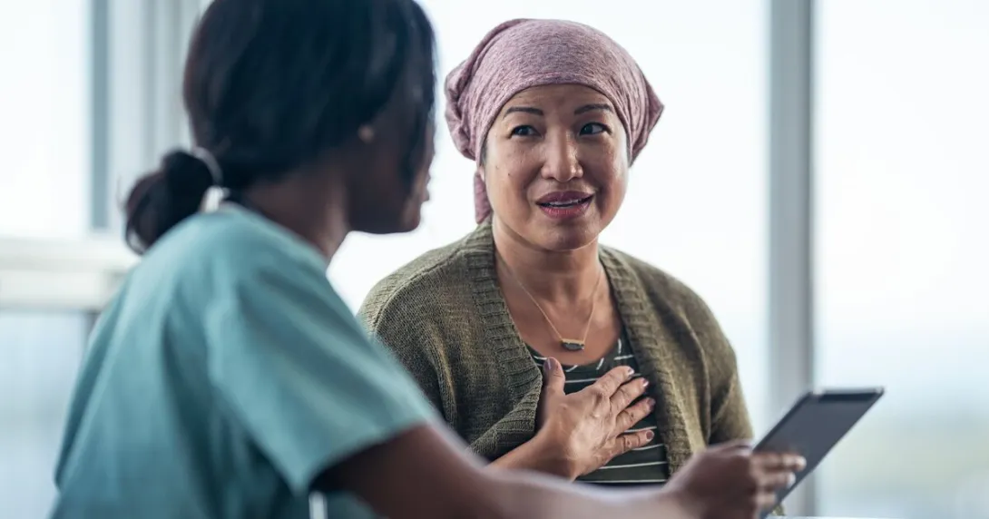 A nurse discussing a cancer patient's treatment plan using a digital tablet A nurse discussing a cancer patient's treatment plan using a digital tablet