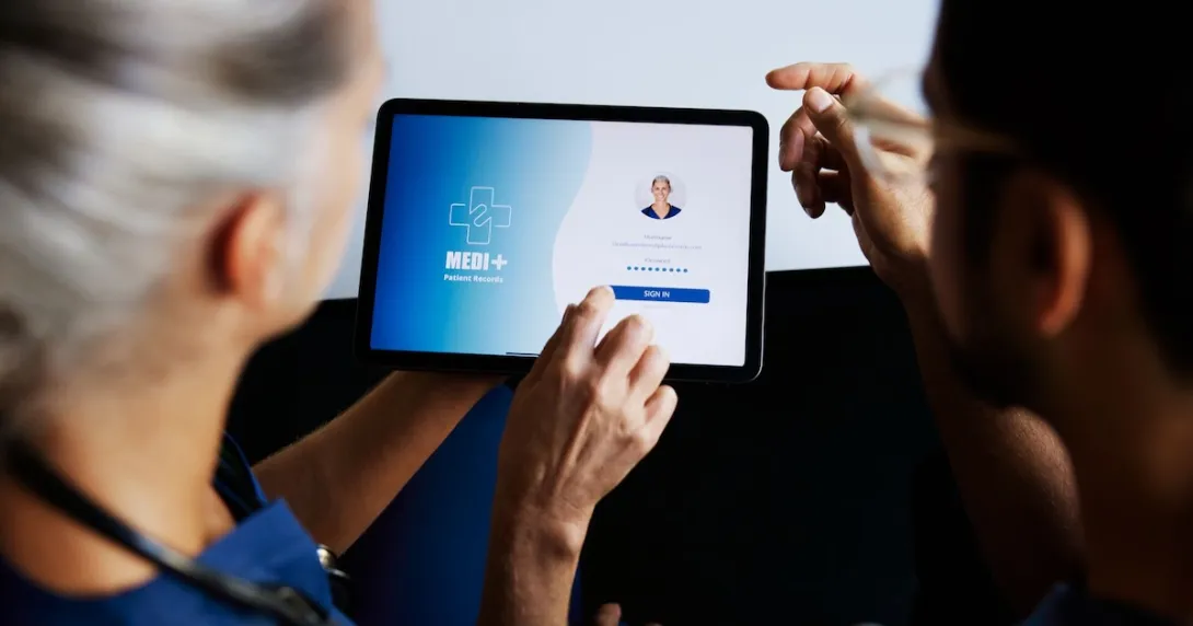 A nurse entering their portal login details on a digital tablet A nurse entering their portal login details on a digital tablet