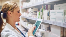 Pharmacist taking inventory with a tablet