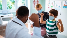 Doctor seeing pediatric patient and parent with masks on