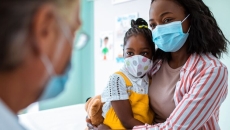 Patient and child in mask visiting doctor