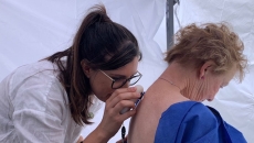 Clinician conducts mole check on female patient