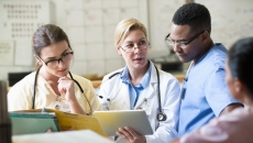 A team of medical staff with a digital tablet