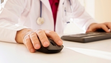Person in white jacket operates keyboard and mouse