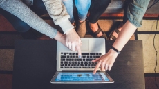 Teenagers pointing at a laptop screen
