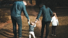 A family of four walking side by side