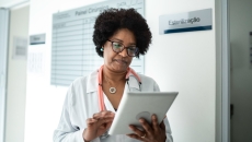 A provider looks at patient forms on a tablet