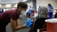 A person gives a vaccine to an adult